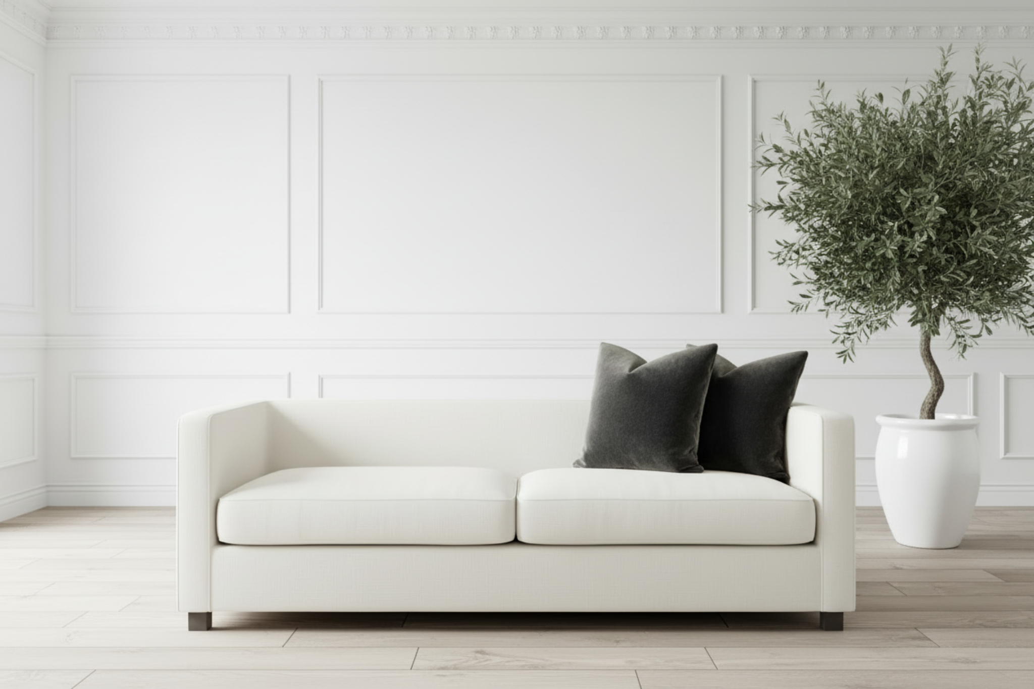 White sofa with black pillows in a minimalistic living room.