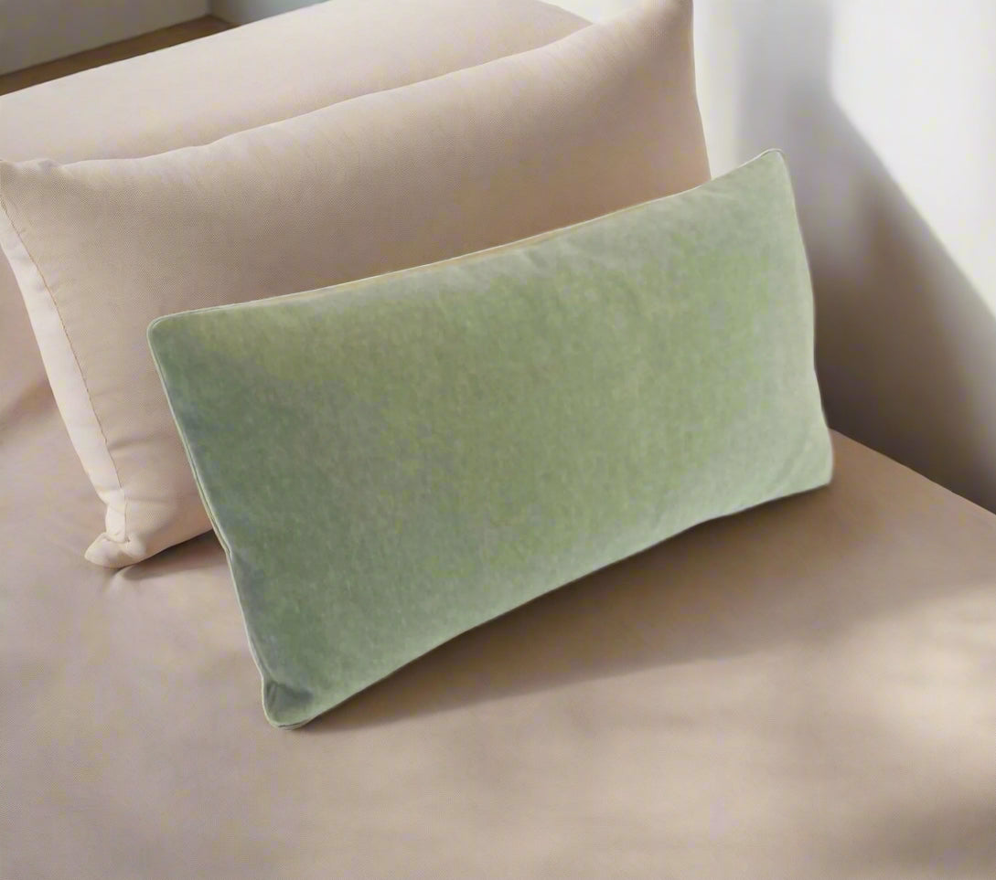 Green pillow on a beige couch