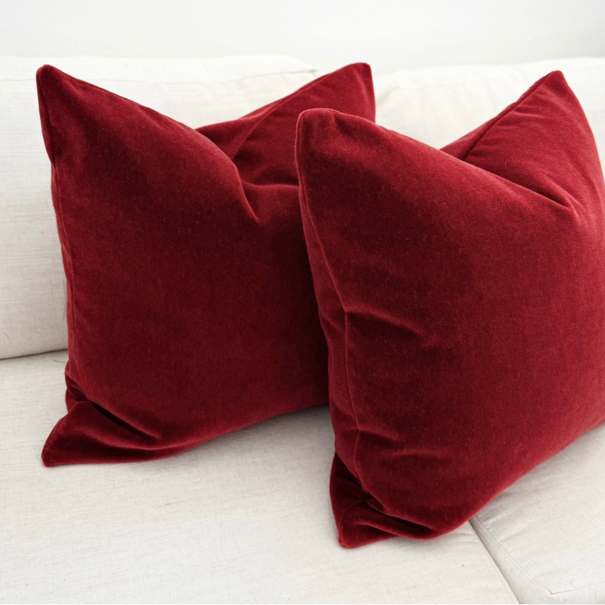 Two red pillows on a white couch